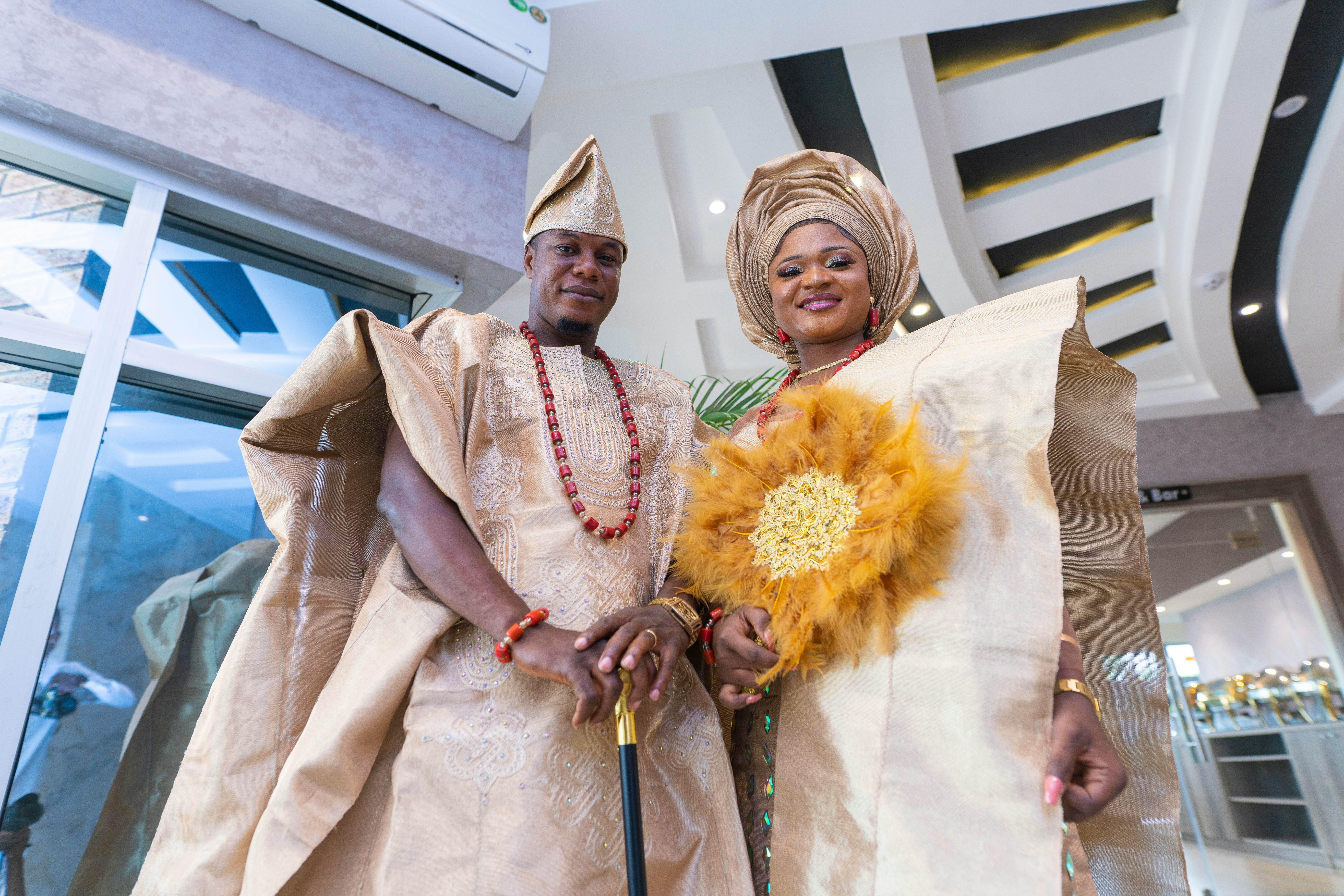 Bride and groom in matching aso oke outfits at a Yoruba traditional wedding ceremony