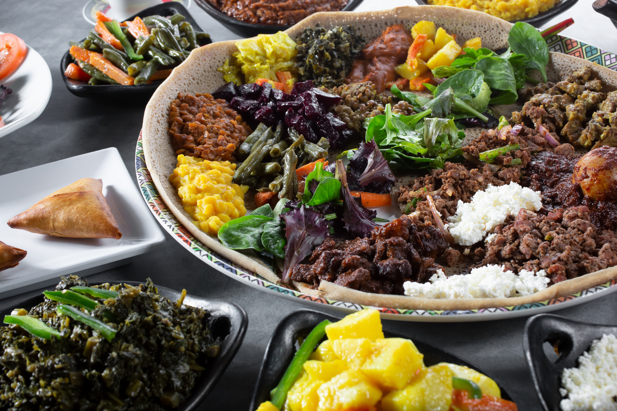 Traditional Ethiopian wedding feast served on injera with various wots arranged on a large mesob platter