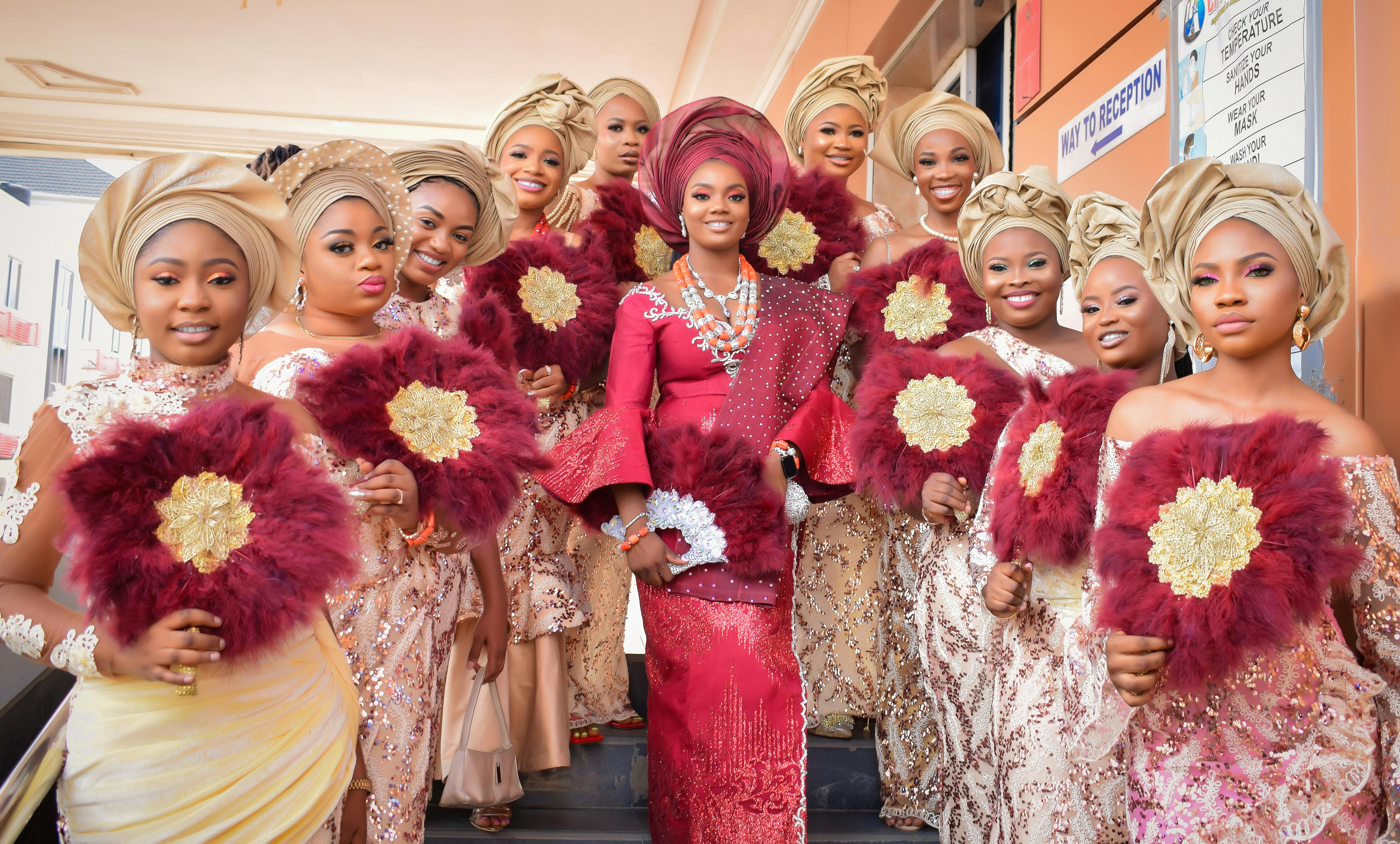 Guests at a Nigerian traditional wedding dressed in coordinating aso ebi outfits in bright colors