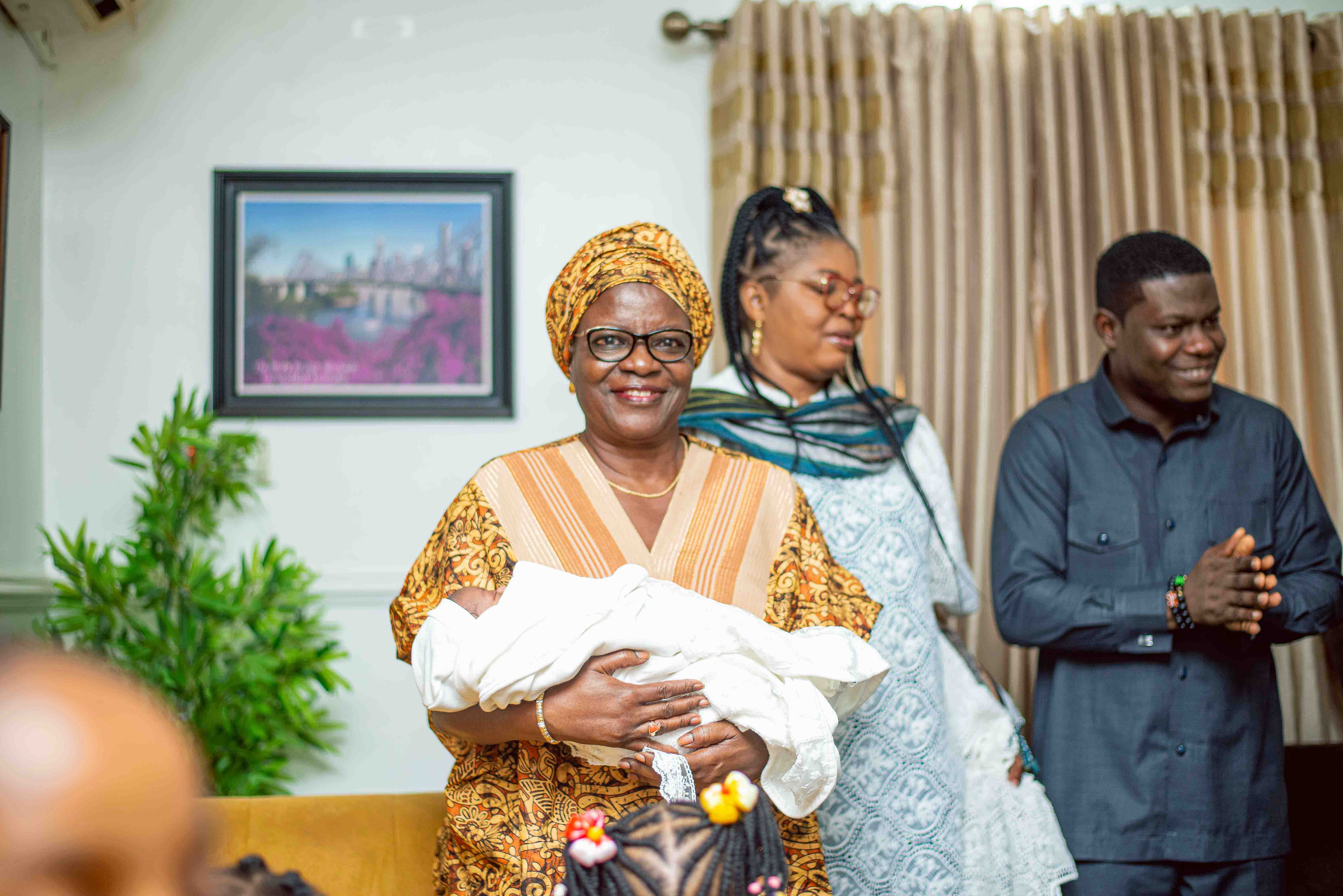 Nigerian naming ceremony with family gathered around a newborn